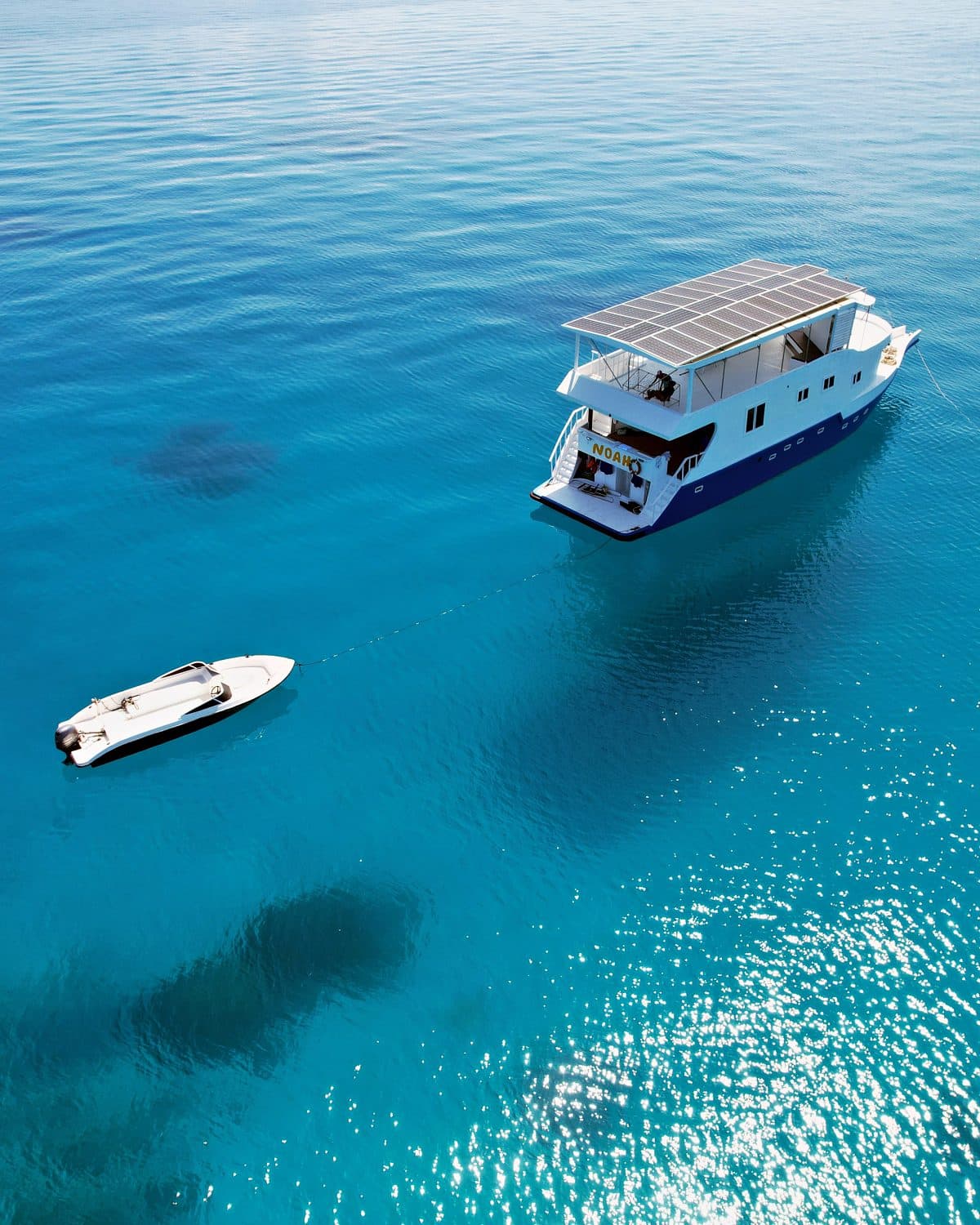 NOAH's stern and dinghy on sparkling blue water