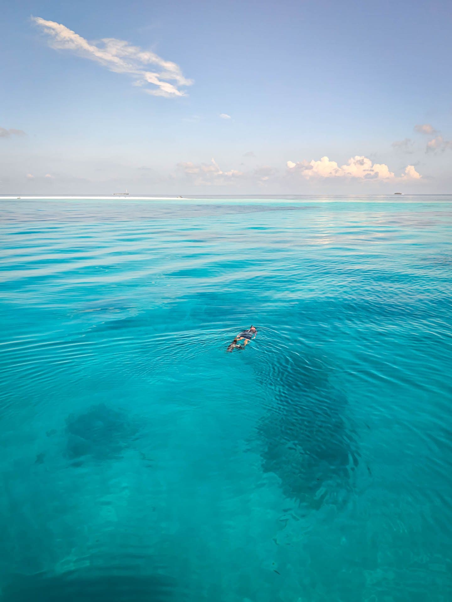Snorkeller over coral heads in a clear lagoon