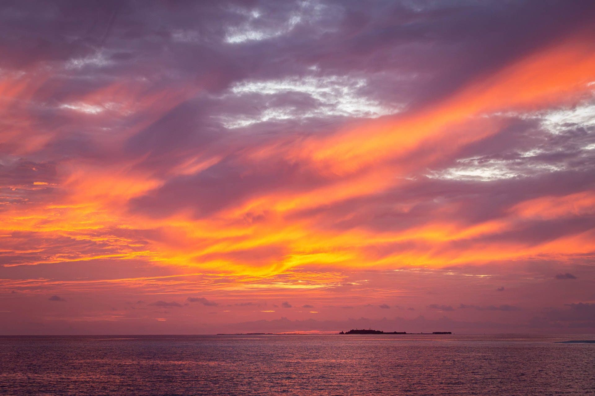 Fiery Maldivian sunset sky over the sea