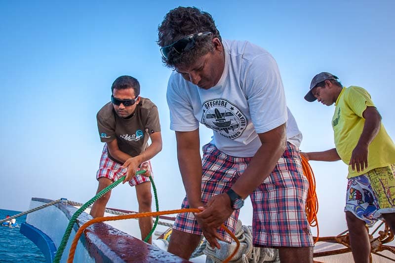 NOAH crew members hauling the anchor lines together on the bow