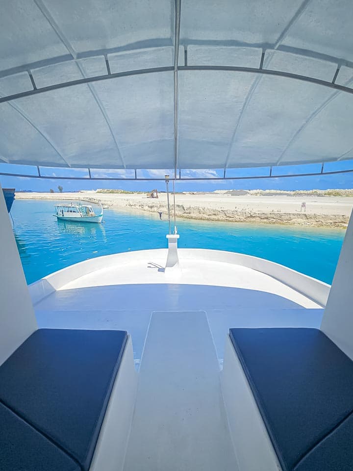 Bow seating under NOAH's canopy over bright turquoise water