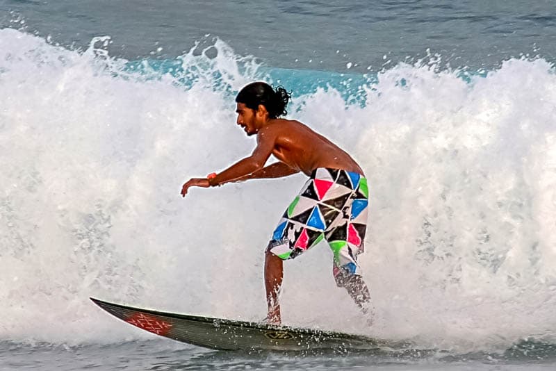 Surfer riding a breaking wave in the Maldives