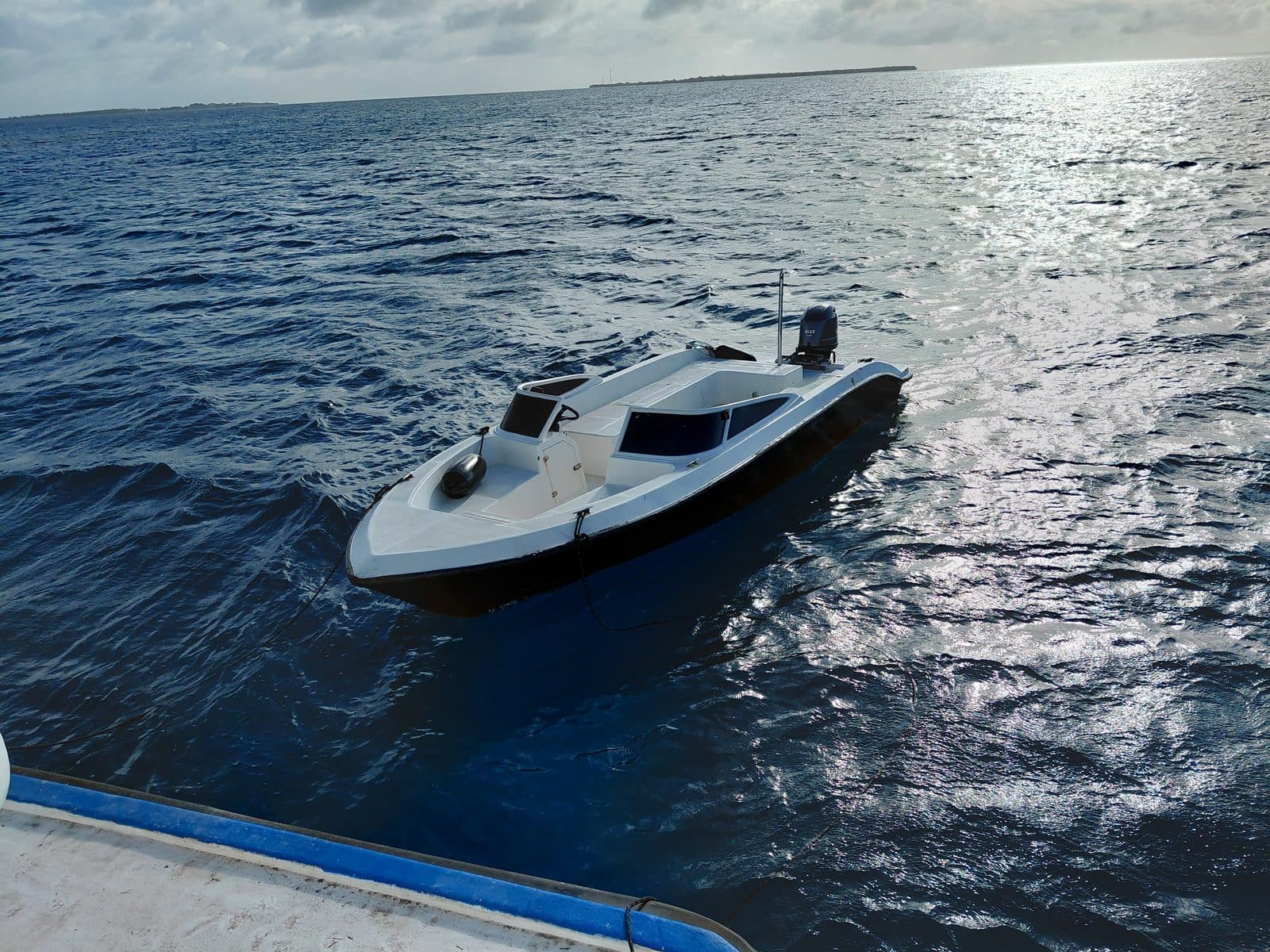 NOAH's dinghy with its 60 HP outboard, moored alongside the boat