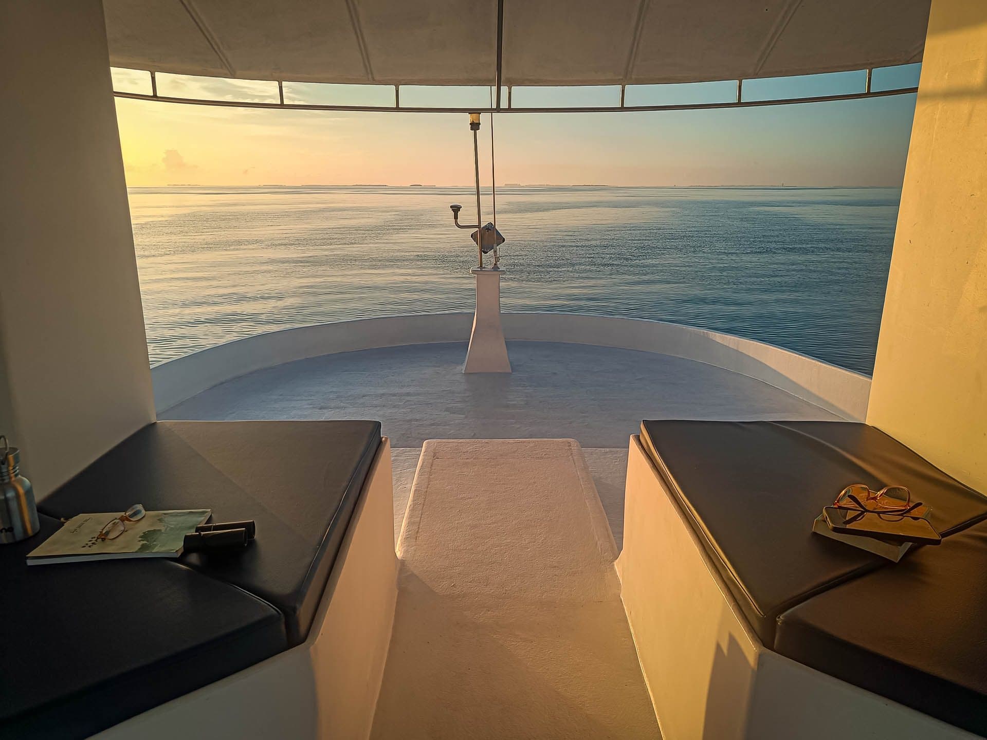 Cushioned loungers at NOAH's bow in early golden light