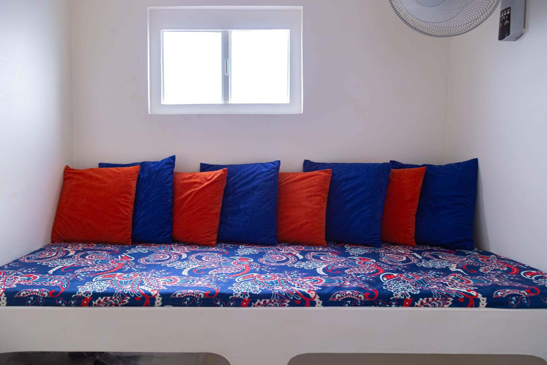 Sofa bed with red and blue cushions in a NOAH cabin