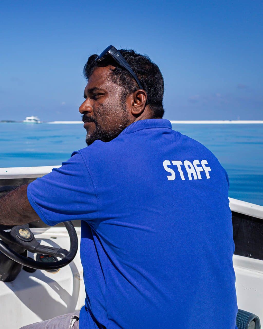 Captain Sunil at the wheel of NOAH's dinghy, NOAH anchored behind