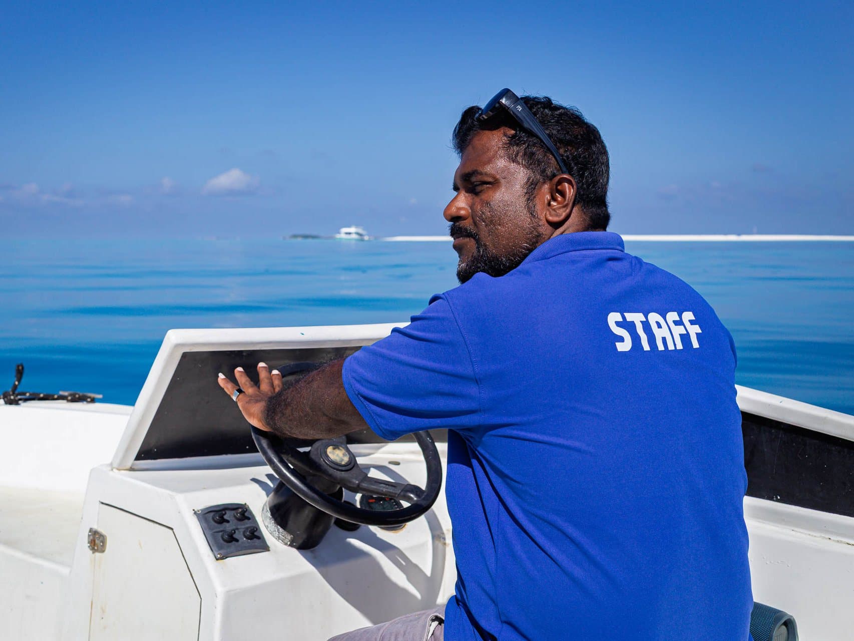 Captain Sunil at the wheel of NOAH's dinghy, NOAH anchored behind
