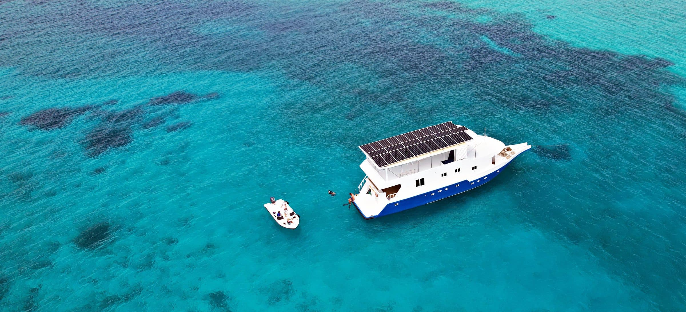 Aerial view of the NOAH safari boat anchored above a coral reef