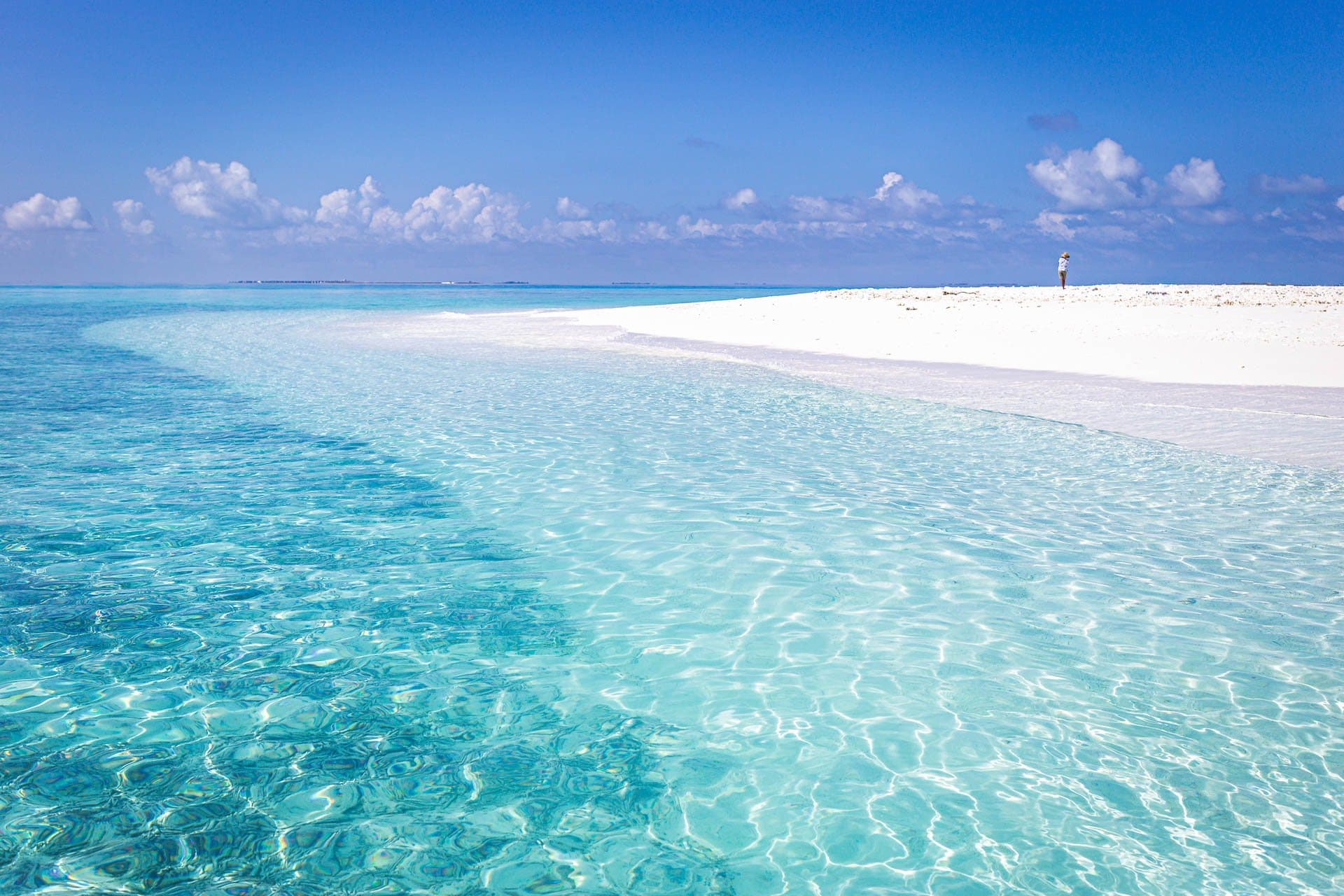 A white sandbank curving through a turquoise Maldivian lagoon