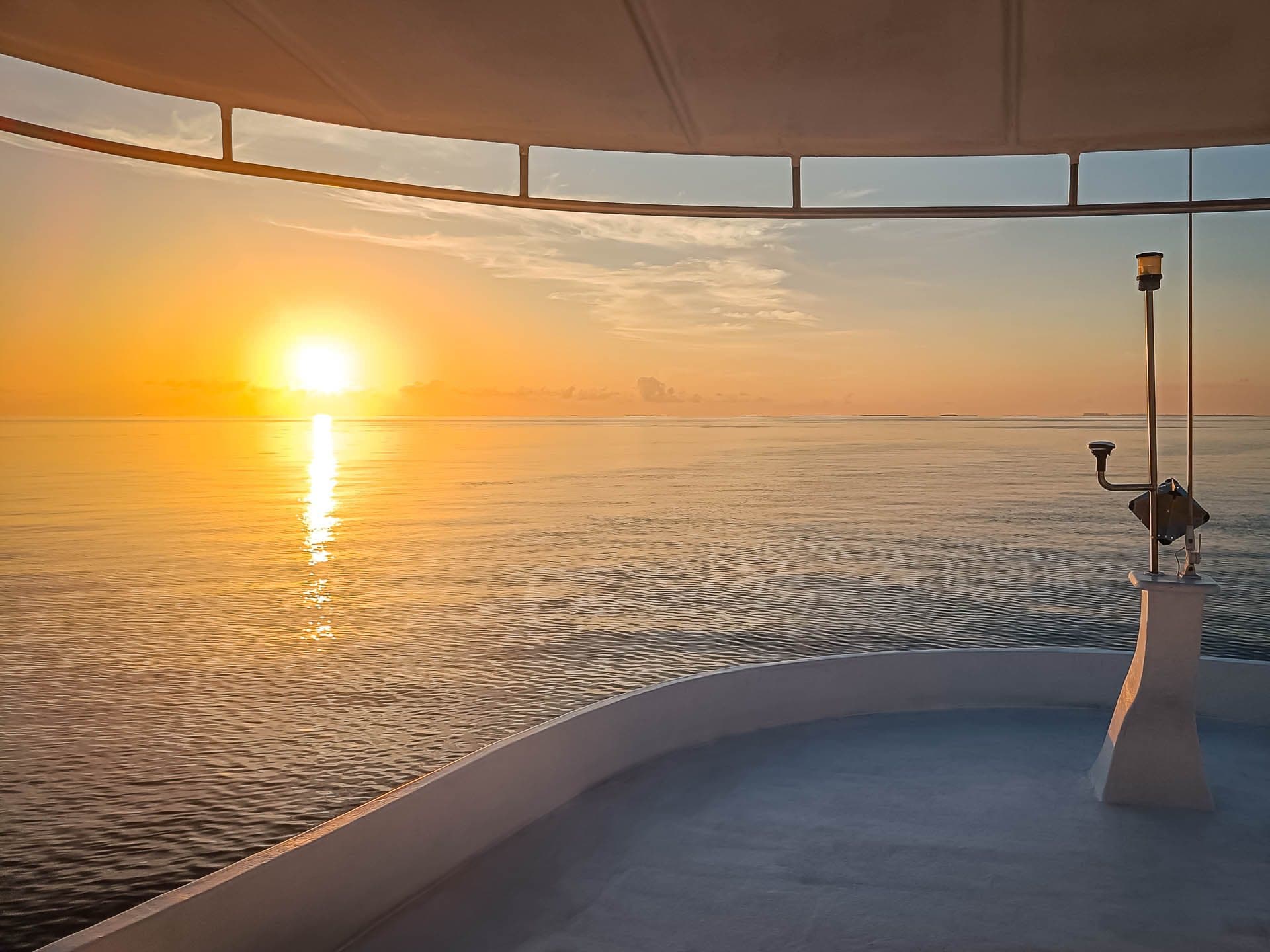Sunrise over calm water seen from NOAH's bow