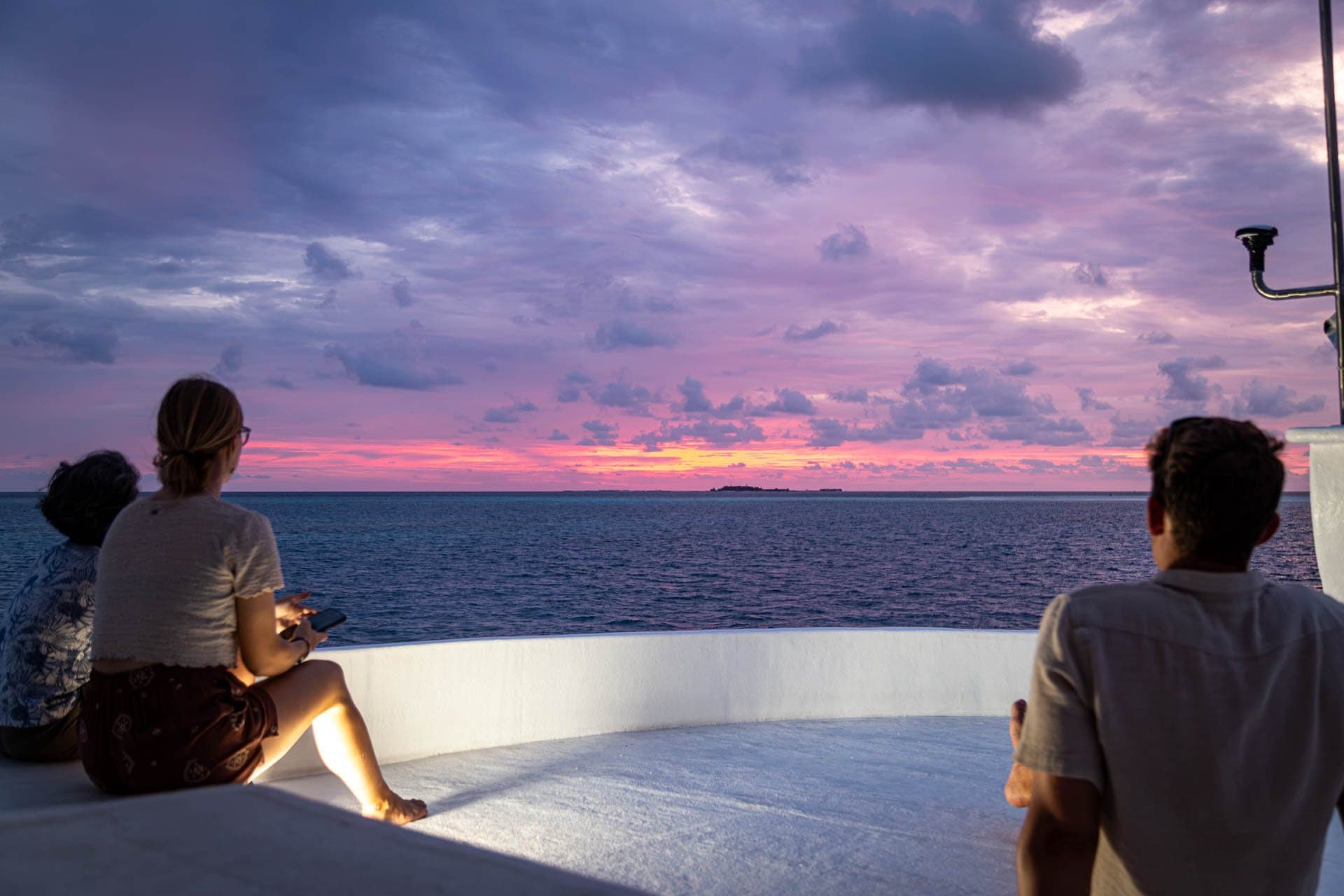 Guests watching a pink sunset from NOAH's top deck
